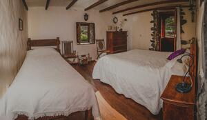 Rustikales Schlafzimmer mit Doppelbett und Einzelbett und antiken Möbeln